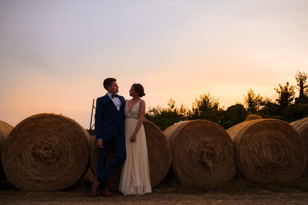 hay bales and happy couple on the working farm at slip-on
